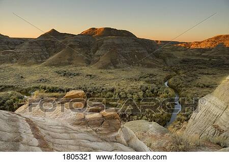 Stock Image - Sunrise in the badlands with valley in Alberta, Canada. Fotosearch