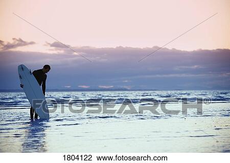 Stock Image - Surfer in the shallow water . Fotosearch