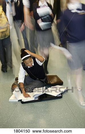 Teenage girl doing homework in middle of school hall View Large Photo Image Stock Image - Teenage girl doing homework in middle of school hall. Fotosearch
