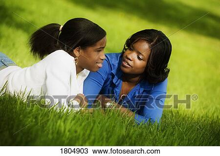 Teenage girls reclining in grass View Large Photo Image Stock Image - Teenage girls reclining in grass. Fotosearch