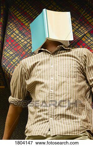 Teenager sleeping with book covering face View Large Photo Image Stock Photo - Teenager sleeping with book covering face. Fotosearch