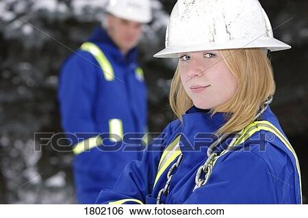Stock Photograph - Tradeswoman with tradesman out of focus. Fotosearch