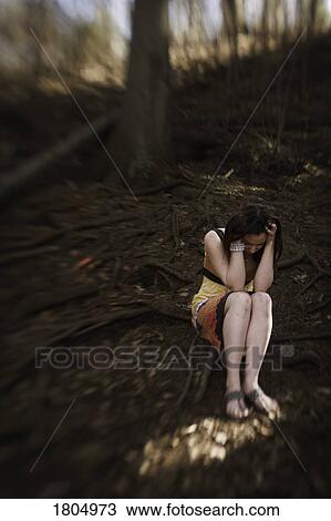 Stock Image - Troubled woman holding head in hands. Fotosearch