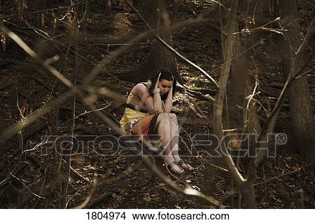 Picture - Troubled young woman holding head in hands. Fotosearch