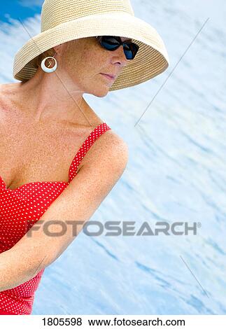 Woman at the pool wearing sunglasses and sun hat View Large Photo Image Stock Photo - Woman at the pool wearing sunglasses and sun hat. Fotosearch