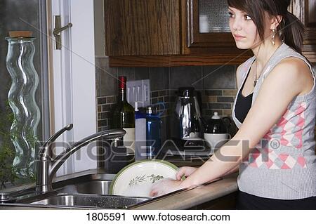 Stock Image - Woman cleaning dishes. Fotosearch