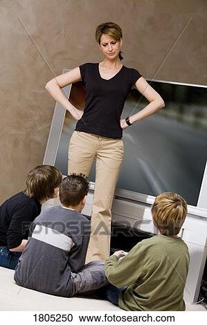Woman frustrated with boys for playing video game View Large Photo Image Stock Image - Woman frustrated with boys for playing video game. Fotosearch
