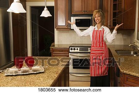 Woman in kitchen wearing apron View Large Photo Image Stock Photography - Woman in kitchen wearing apron. Fotosearch