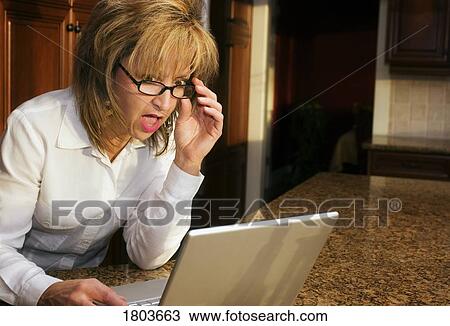 Woman looking surprised at computer View Large Photo Image Stock Image - Woman looking surprised at computer. Fotosearch