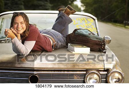 Woman posing on the hood of a retro car View Large Photo Image Stock Photo - Woman posing on the hood of a retro car. Fotosearch