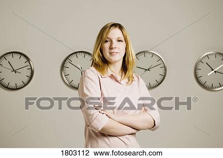 Woman standing in front of clocks View Large Photo Image Stock Image - Woman standing in front of clocks. Fotosearch