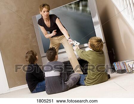 Woman stopping boys for playing video game View Large Photo Image Stock Image - Woman stopping boys for playing video game. Fotosearch