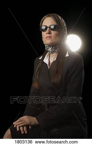 Stock Photograph - Woman wearing a scarf and sunglasses. Fotosearch