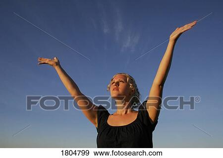Stock Photo - Woman with her arms raised. Fotosearch