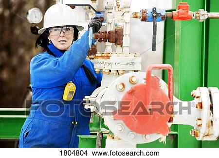 Picture - Woman working on an boiler system. Fotosearch