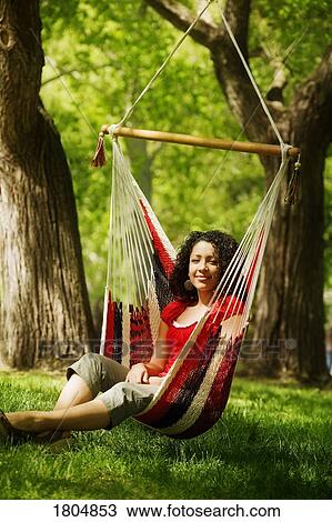 Young adult female sitting on hammock View Large Photo Image Stock Image - Young adult female sitting on hammock. Fotosearch