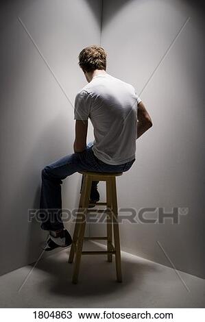 Stock Image - Young man sitting on a stool. Fotosearch