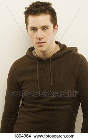 Young man wearing brown hooded sweater View Large Photo Image Picture - Young man wearing brown hooded sweater. Fotosearch