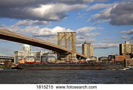 A barge passing underneath Brooklyn Bridge, Lower Manhattan, New York City, New York, USA View Large Photo Image Stock Photography - A barge passing underneath Brooklyn Bridge, Lower Manhattan, New York City, New York, USA. Fotosearch