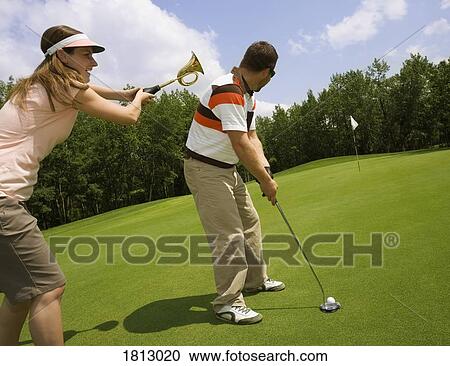 Stock Image - A couple playing golf. Fotosearch