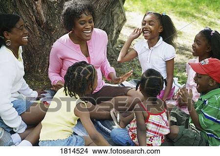 A group of people sitting in the park View Large Photo Image Picture - A group of people sitting in the park. Fotosearch