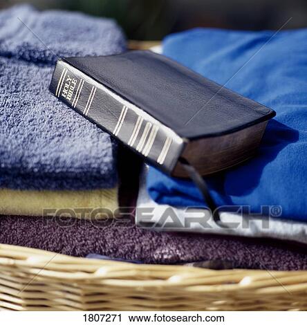 Stock Image - Bible placed on top of folded laundry. Fotosearch
