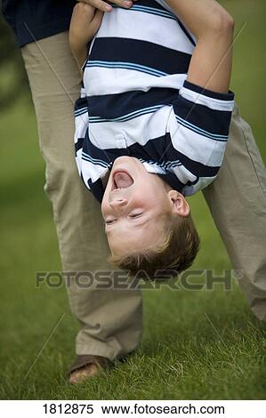 Stock Photography - Boy hanging upside down. Fotosearch