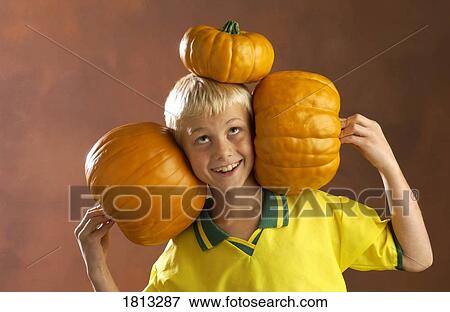 Boy playing with pumpkins View Large Photo Image Stock Photo - Boy playing with pumpkins . Fotosearch