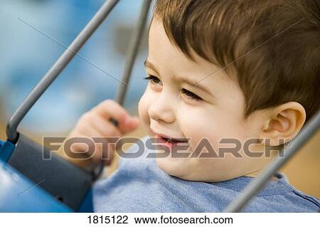 Stock Image - Boy smiling on swing. Fotosearch
