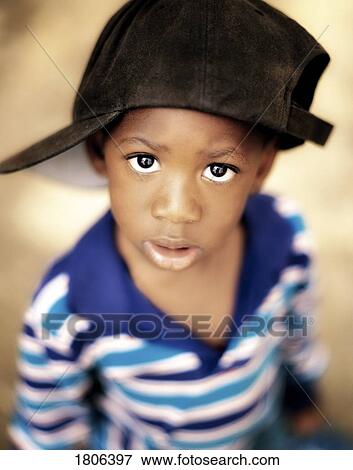 Boy wearing over sized hat sideways View Large Photo Image Stock Photo - Boy wearing over sized hat sideways. Fotosearch