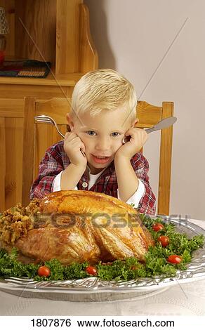 Boy with cooked turkey at table View Large Photo Image Stock Photograph - Boy with cooked turkey at table . Fotosearch