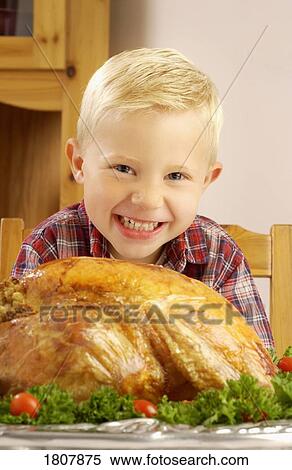 Stock Photography - Boy with roast turkey at table . Fotosearch