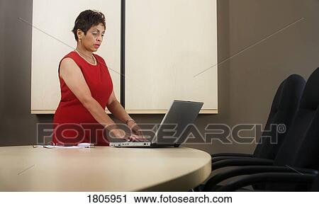 Stock Image - Businesswoman working on laptop. Fotosearch