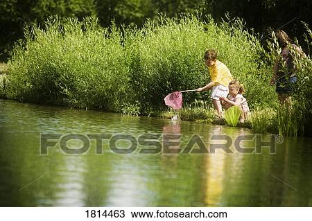 Children fishing in a pond View Large Photo Image Stock Image - Children fishing in a pond. Fotosearch