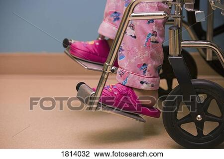 Stock Image - Child's feet in hospital wheelchair. Fotosearch