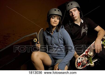Stock Photograph - Couple holding skateboards. Fotosearch