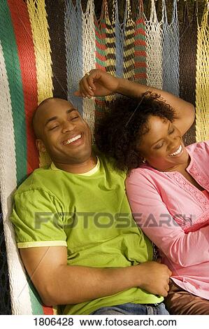 Couple laughing in hammock View Large Photo Image Stock Photo - Couple laughing in hammock. Fotosearch