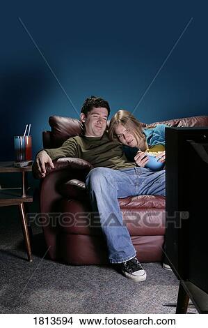 Picture - Front view of a couple watching television. Fotosearch