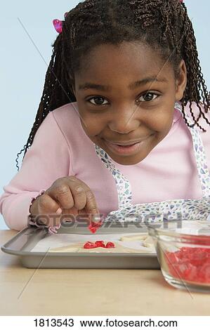 Stock Image - Front view of girl garnishing food. Fotosearch