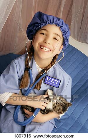 Stock Photograph - Front view of girl sitting with cats. Fotosearch