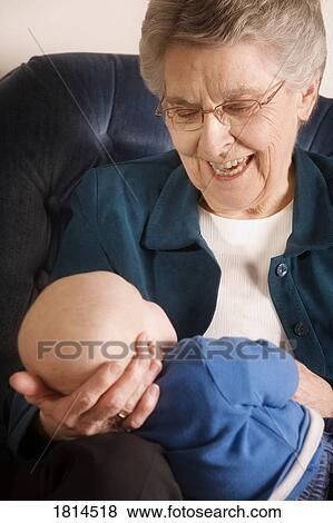 Stock Photo - Front view of grandmother holding a baby. Fotosearch