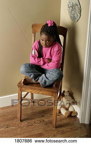 Girl on chair in the corner View Large Photo Image Stock Photograph - Girl on chair in the corner. Fotosearch
