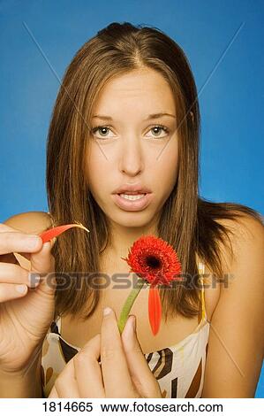 Stock Photography - Girl pulling petals off a flower. Fotosearch
