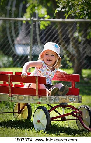 Picture - Girl sitting in wagon. Fotosearch