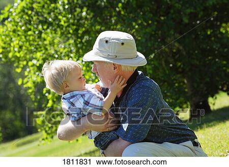 Stock Image - Grandpa holding grandson. Fotosearch