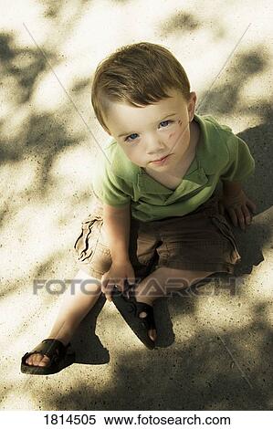 Stock Photography - High angle view of boy sitting. Fotosearch