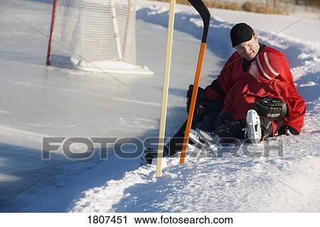 Stock Image - Ice hockey players sitting on snow. Fotosearch
