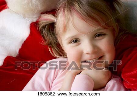 Stock Image - Little girl in the arms of Santa. Fotosearch