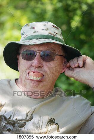 Stock Photography - Man sticking dentures out. Fotosearch