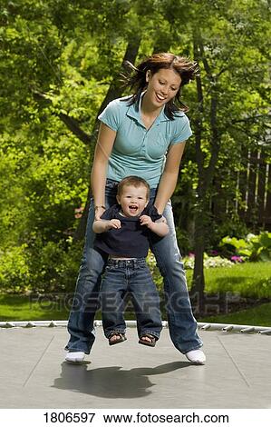 Mother and child jumping on trampoline View Large Photo Image Stock Photo - Mother and child jumping on trampoline. Fotosearch